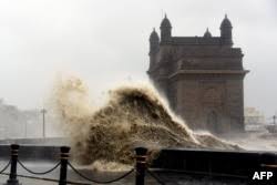 Gelombang yang disebabkan oleh Topan Tauktae menghantam kawasan pejalan kaki dekat monumen Gateway of India di Mumbai, India, 17 Mei 2021. Foto: AFP.