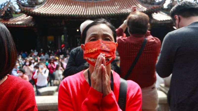 Warga Taiwan berdoa sambil memakai masker di Kuil Lungshan. (GETTY IMAGES)