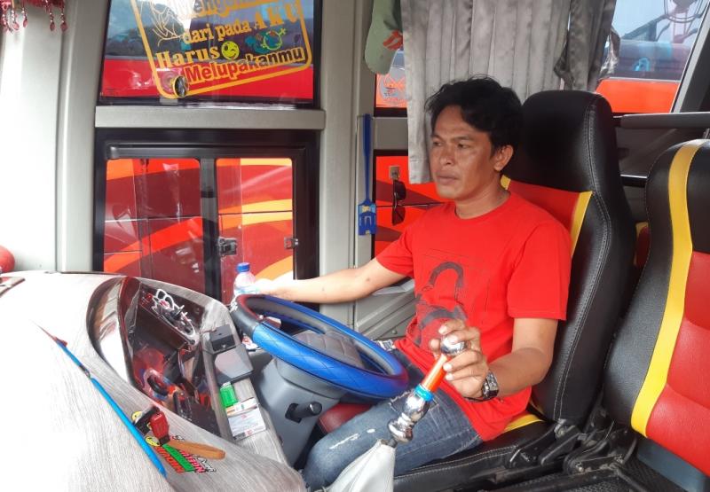 Pengemudi bus Minanga Express, Rinto sedang menaikkan penumpang dari Terminal Bekasi, Jawa Barat, Jumat (18/6/2021).