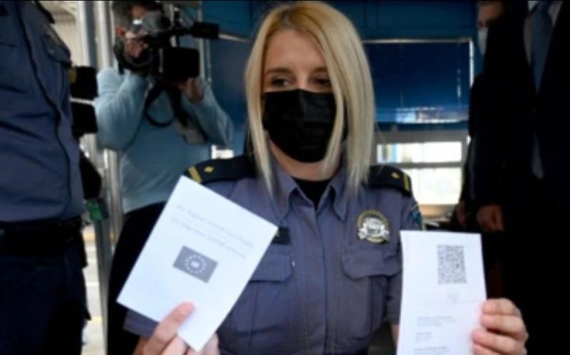 Polisi perempuan di perbatasan Bregana antara Kroasia dan Slovenia menunjukkan paspor COVID digital Uni Eropa, 2 Juni 2021. (Denis LOVROVIC / AFP)