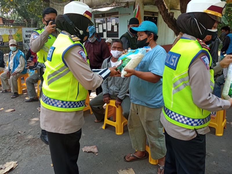 Satlantas Polres Metro Bekasi Kota membagikan beras kepada pengemudi ojek pangkalan, Senin (26/7/2021). Foto: Humas Polrestro Bekasi