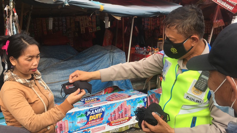 Kanitlantas Bekasi Timur, Iptu. M Sahari, bagikan masker gratir ke warga sekitar Gerbang Tol Bekasi Timur, Kamis (5/8/2021). Foto: BeritaTrans.com.