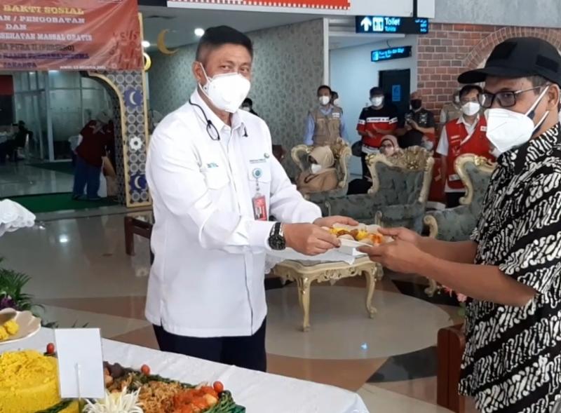 Pemberian tumpeng kepada perwakilan masyarakat menerima bantuan sosial oleh Executive General Manager PT Angkasa Pura II (Persero), Bandara Halim Perdanakusuma, Jakarta  Marsma TNI Nandang Sukarna saat pergelaran di Bandara, Jumat (13/8/2021).
