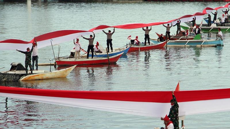  TNI - Polri dan nelayan bentangkan bendera Merah Putih di Pantai Losari, Makassar.