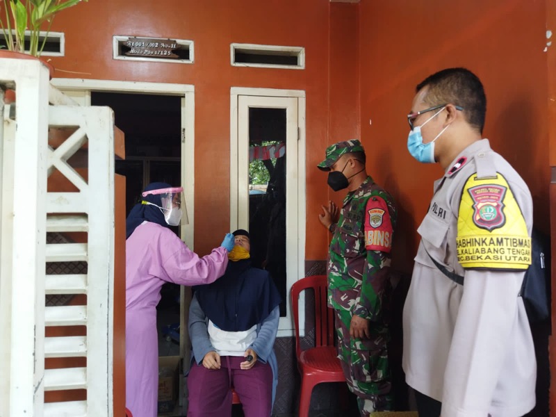 Petugas kepolisian dari Polsek Bekasi Utara bersama dengan tim medis dari Puskesmas, melakukan tracking kepada sejumlah warga kelurahan Kaliabang Tengah dengan melakukan Swab antigen. Foto: Polrestro Bekasi Kota.