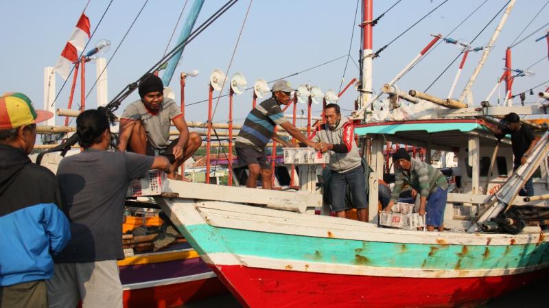 Kapal nelayan sedang menurunkan ikan hasil tangkap. (Foto:Istimewa)