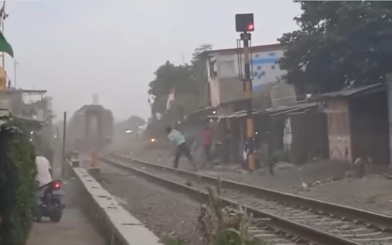 Potongan gambar dari video yang menampilkan seorang berbaju biru muda tampak melayangkan benda ke kereta api yang melintas di petak Kiaracondong-Gedebage.