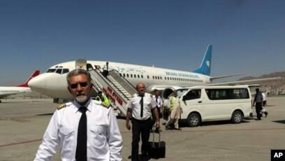 Sekelompok pilot dari maskapai Ariana Afghan tampak berjalan di area Bandara Internasional Hamid Karzai di Kabul, Afghanistan, setelah mendarat pada 5 September 2021. (Foto: AP)