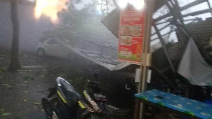 Beberapa unit kendaraan rusak tertimpa reklame yang roboh di salah satu cafe di Jalan Margonda Raya, Depok akibat angin kencang disertai hujan deras, Selasa (21/9/2021). (Foto:Twitter/tempo)
