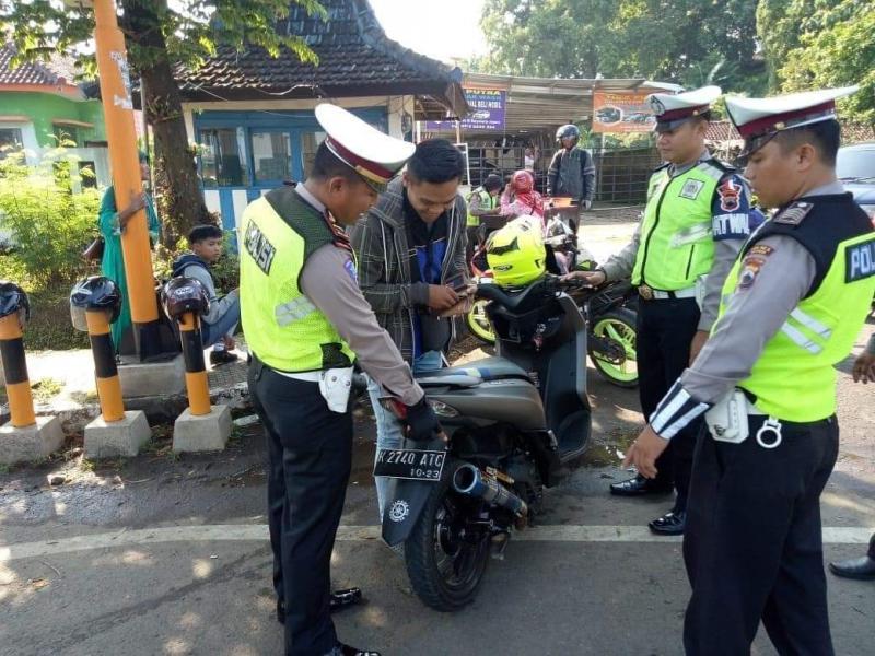 Polisi Lalu lintas menilang pengendara sepeda motor saat Operasi Patuh Jaya 2020 di Jalan Letjen Suprapto, Jakarta Pusat.