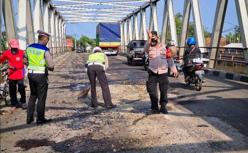 Petugas menyapu pasir di jembatan Cilet. Semula pasir itu untuk menutup tumpahan solar dari  tangki Elf yang bocor menggenangi permukaan jembatan Cilet. (Ist.)       