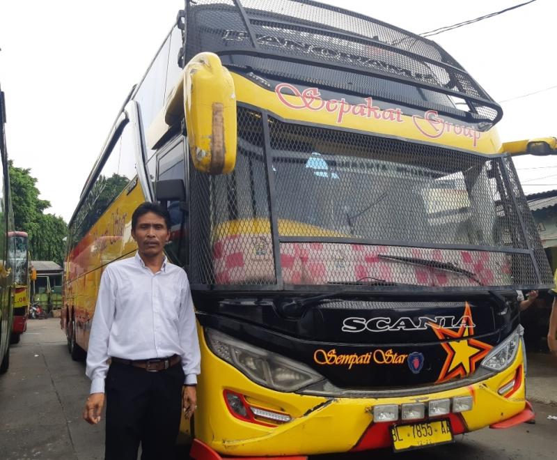 Ansari berpose dengan bus Sempati Star besasis Scania dengan pelindung kaca depan menggunakan jaring besi yang dikendarainya lintas rute Jakarta-Medan. 