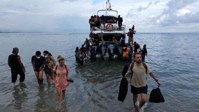 Wisatawan yang telah usai berlibur di Pulau Nusa Penida turun dari kapal cepat setibanya di Pelabuhan Sanur, Denpasar, Bali.