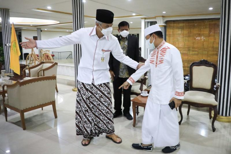 Gubernur Jawa Tengah, Ganjar Pranowo mengenakan sarung Lar Gurda buatan santri Solo di hadapan Ustad Das’ad Latif. (Ist.)