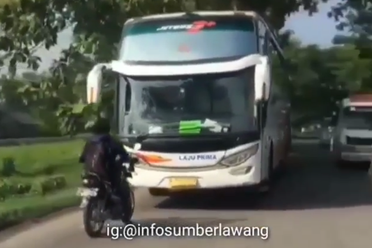 Tangkapan layar video yang menampilkan pengendara sepeda motor dengan beraninya mengadang bus Laju Prima yang melawan arah di Sragen, Jawa Tengah. Foto: instagram/@infosumberlawang/kompas.com.