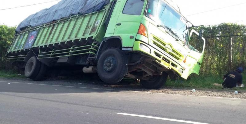 Ban belakang kiri terperosok lubang di bahu jalan mengakibatkan ban depan kanan terangkat beberapa centi meter. (Taryani) 