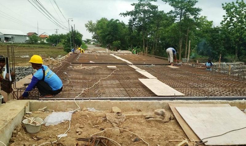 Beberapa orang tukang bangunan, Minggu (7/11/2021)  sedang memasang rancangan besi beton untuk dak atau alas jembatan Haurkolot yang sedang diperbaiki. (Taryani) 