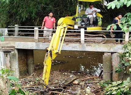 Pembersihan sampah menggunakan alat berat yang menggunung di bawah jembatan Desa Sidorejo, Kecamatan Sedan, Senin (15/11/2021). (Ist.)