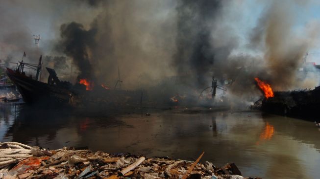 Asap mengepul dari kapal pencari ikan yang terbakar di galangan kapal Pelabuhan Tegal, Jawa Tengah, Rabu (17/11/2021). ANTARA FOTO/Oky Lukmansyah