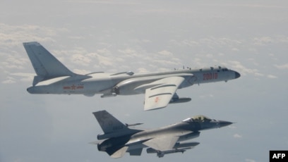 Pesawat tempur F-16 (bawah) milik Taiwan terbang di dekat pesawat pengebom H-6 milik China di wilayah udara Taiwan pada 10 Februari 2020. (Foto: Handout/Taiwan`s Defence Ministry/AFP)