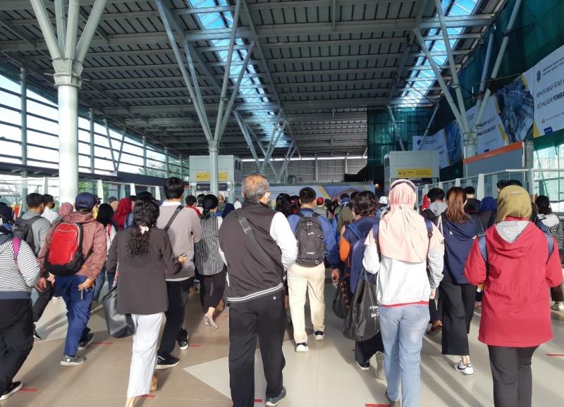 Barisan antrean penumpang KRL berjalan hendak melakukan tap tiket di bangunan baru Stasiun Bekasi, Senin (29/11/2021).