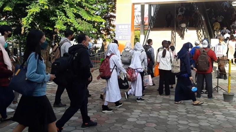 Bocah dengan seragam sekolah tampak ikut antre memasuki bangunan baru Stasiun Bekasi, Senin (29/11/2021).