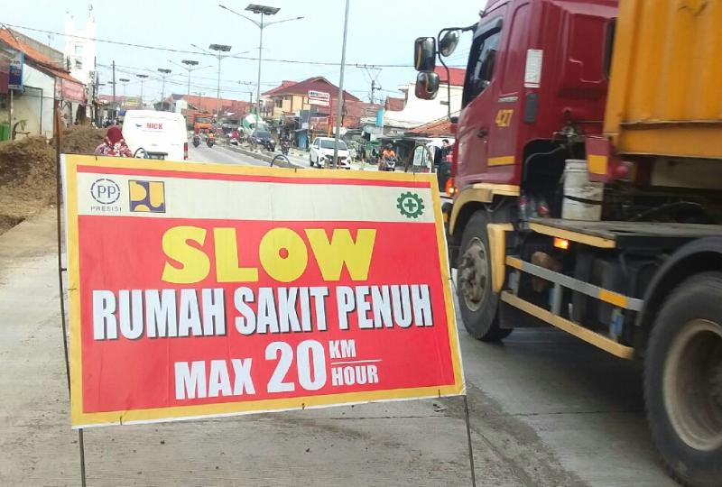 Pengumuman yang ditujukan kepada para pengendara kendaraan bermotor saat melintasi area proyek perbaikan jalan beton dan drainase di Indramayu, Jawa Barat. (Taryani)