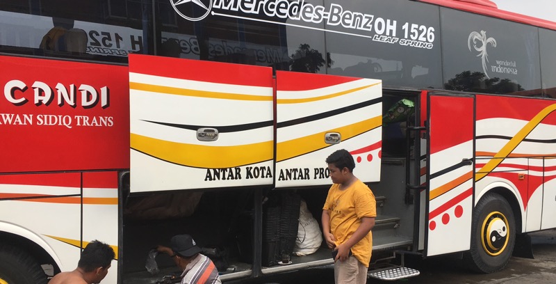 Angga Dwi Saputra (kanan) tengah memperhatikan sang bapak (kiri) dan seorang mekanik (tengah) memperbaiki bus di Terminal Bekasi, Rabu (22/12/2021). Foto: BeritaTrans.com.