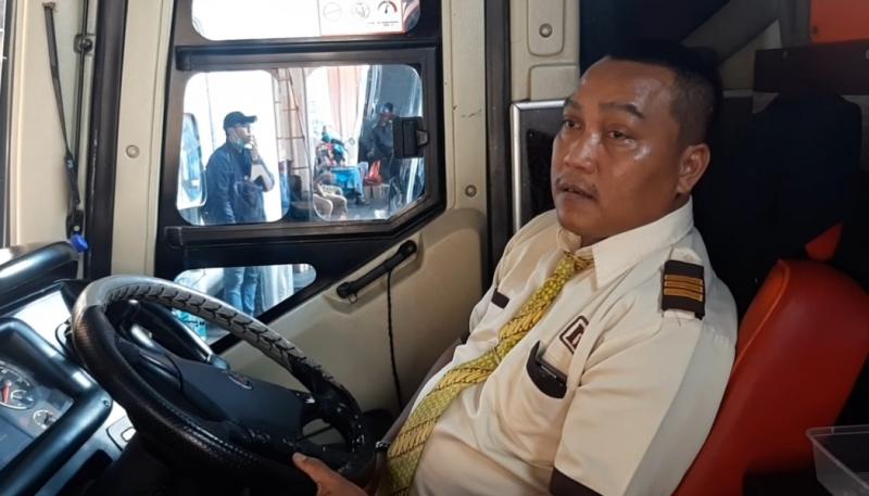 Pengemudi bus Rosalia Indah, Adi Bulung saat menaikkan penumpang di pool Bulak Kapal, Bekasi.