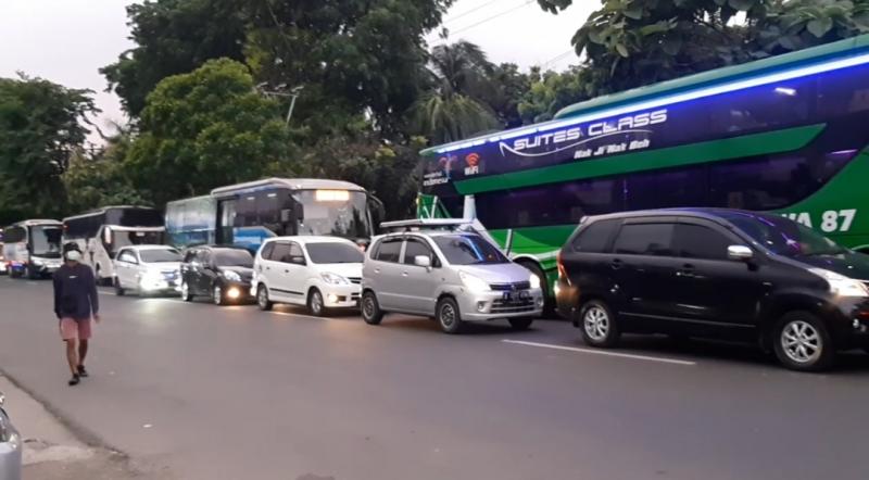 Mobil pribadi dan bus terlihat berbaris di jalan HM Joyo Martono, Bulak Kapal, Bekasi, Senin (3/1/2021). 