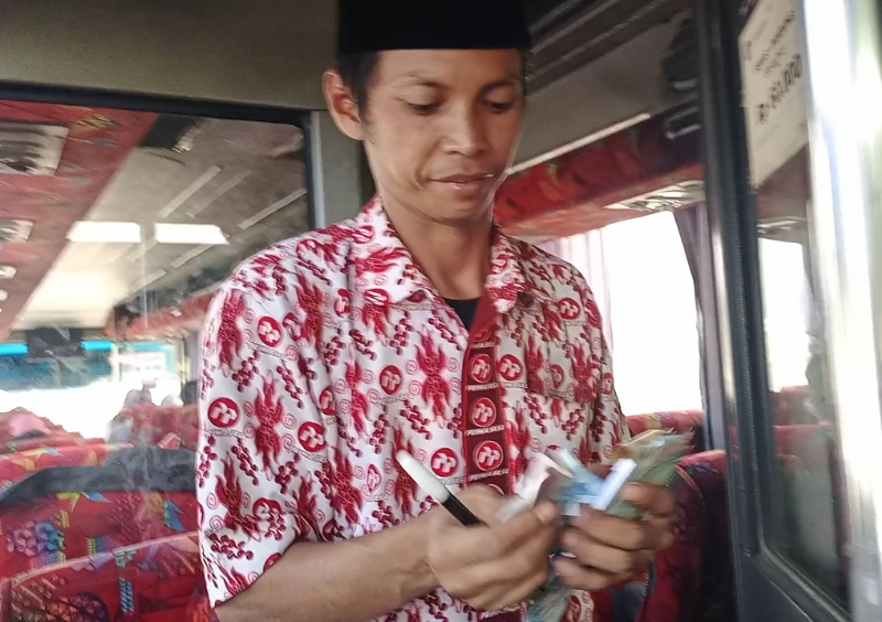 Firman, preman sadar, yang memilih hidup berkah menjadi kondektur bus Primajasa Bandung-Bekasi. Foto: Awe/BeritaTrans.com/Aksi.id.