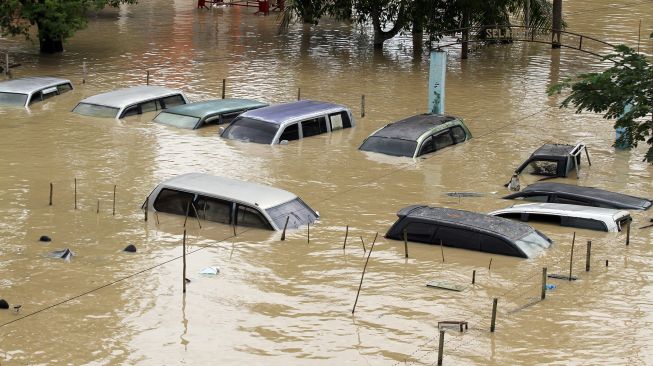 Sejumlah mobil barang bukti Kepolisian terendam saat banjir melanda Kota Lhoksukon, Aceh Utara, Aceh, Senin (3/1/2022). 