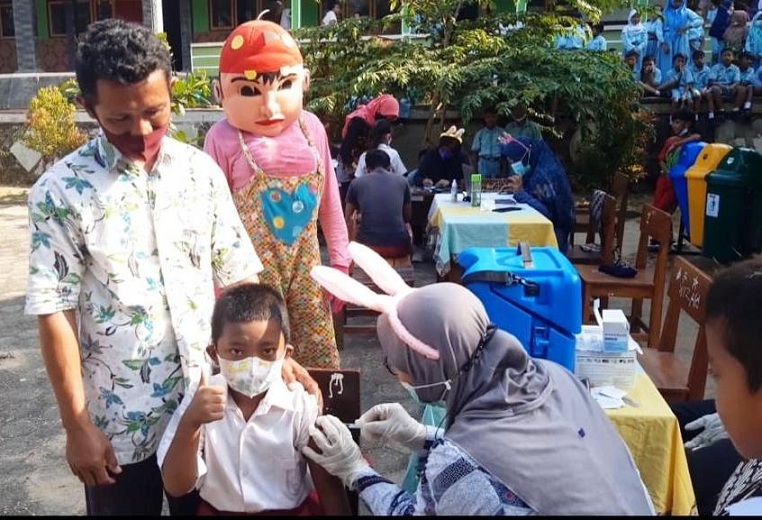 Petugas vaksinasi di Karimunjawa mengenakan pakaian seperti badut sehingga anak usia 6-11 tahun tak takut disuntik. (Ist.)