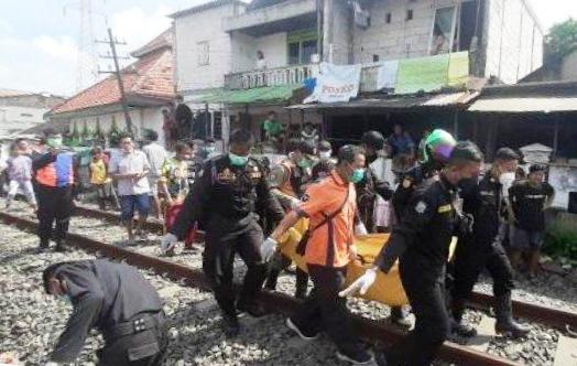 Jenazah kakek naas tersambar kereta api dievakuasi petugas menuju RSUD dr. Soetomo Surabaya. (Foto:Surya.co.id) 