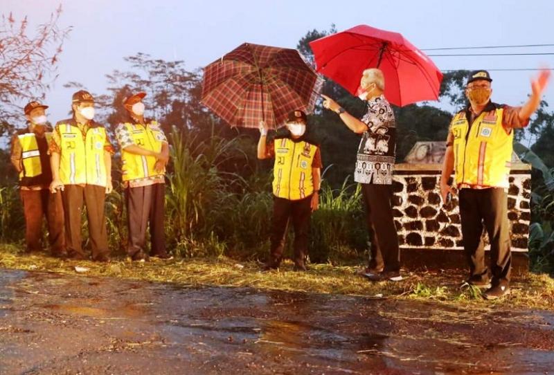 Gubernur Jateng, Ganjar Pranowo berpayung,  karena cuaca hujan menginspeksi mendadak ruas jalan Banjarnegara-Pekalongan. (Dok.Humas Jateng)