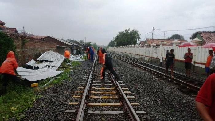 Petugas membersihkan kanopi rumah warga yang roboh dan menimpa rel kereta api di Kota Cirebon. (Dok.Humas PT KAI Daops 3 Cirebon)