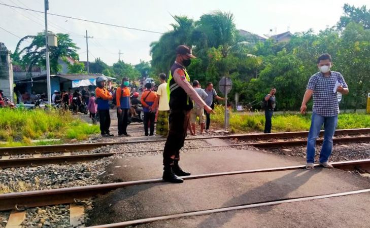 Petugas dari kepolisian menunjukkan lokasi dua pelajar tewas tertabrak ereta api. (Foto:Kompas.com)