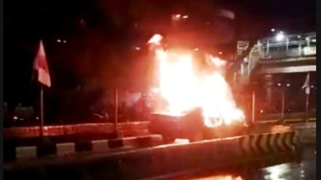 Sedan Toyota Camry terbakar setelah menabrak separator busway. Dua orang penumpang mobil nahas tadi diketahui tewas dalam kecelakaan lalu-lintas itu. (Foto:Dok.Suara.com)