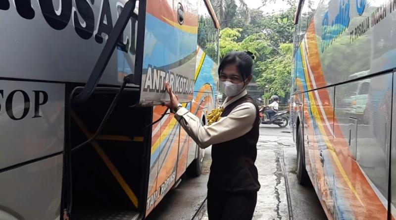 Hesti sedang membuka bagasi bus Rosalia Indah untuk menaikkan beberapa barang bawaan penumpang di Bulak Kapal, Bekasi. 