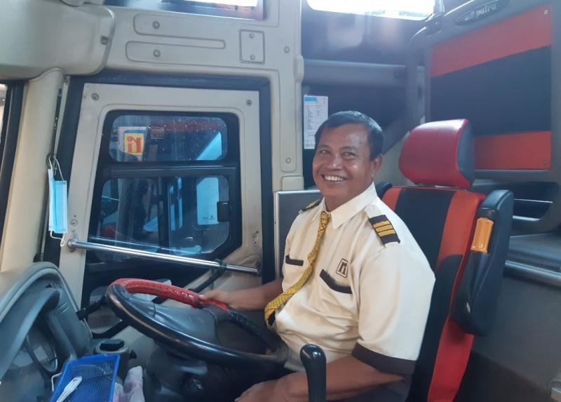 Satiman pengemudi bus jurusan Jakarta-Ponorogo saat menaiikan penumpang di pool bus Rosalia Indah, Bulak Kapal, Bekasi, Jumat (11/2/2022).