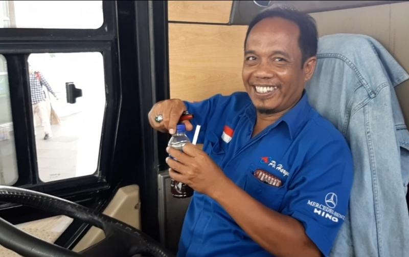 Pengemudi bus PO Haryanto sedang memegang sebotol kopi untuk selalau dikonsumsinya saat perjalanan Jakarta-Kelet. 