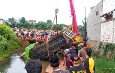 Evakuasi truk bermuatan batu yang terperosok ke kali di Jalan Telaga, Kedaung, Sawangan, Depok, Senin (21/2/2022).