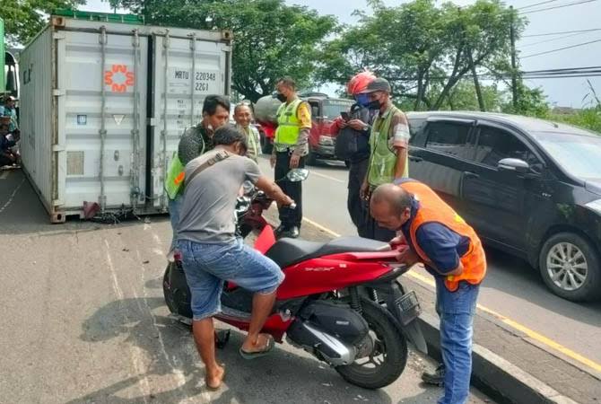 Kondisi kontainer yang jatuh menimpa pemotor. Inset, motor korban saat hendak diamankan. Foto: radarbromo.com,