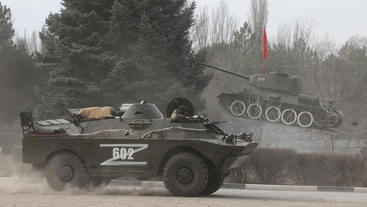 Sebuah kendaraan lapis baja dengan huruf `Z` di atasnya melewati monumen yang menampilkan tank era Soviet, setelah Presiden Rusia Vladimir Putin mengizinkan operasi militer di Ukraina timur.