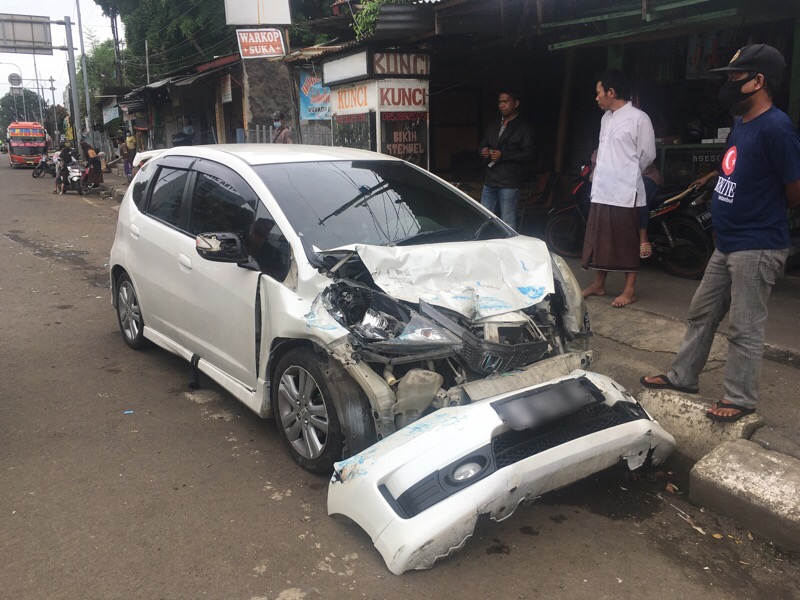 Honda Jazz putih ringsek pada bagian depan usai menabrak minibus elf, Jumat (25/2/2022) siang. Foto: BeritaTrans.com.