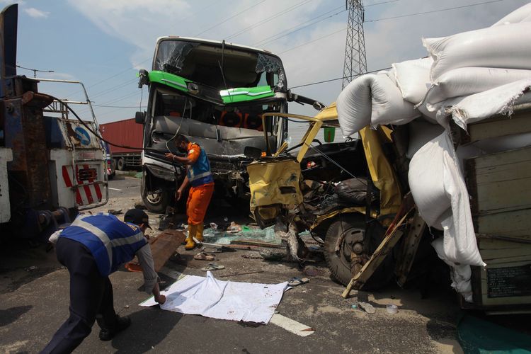 Petugas mengevakuasi bus pariwisata dan truk yang terlibat kecelakaan di Tol Dupak - Tanjung Perak Surabaya, Jawa Timur, Sabtu (5/3/2022). Foto: kompas.com.