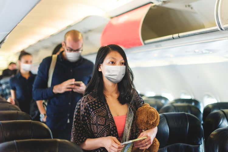 Ilustrasi penumpang pesawat menggenakan masker. Foto: kompas.com.