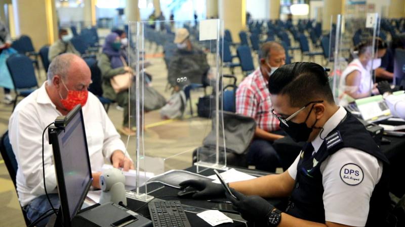 Petugaas di Bandara Ngurah Rai, memeriksa penumpanf baru tiba dari Malaysia