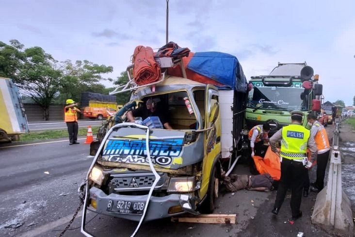 Petugas mengevakuasi korban meninggal dunia. Tampak beberapa truk yang terlibat tabrakan beruntun di Tol Tangerang-Merak Km 68.800A arah Tangerang, Selasa (15/3/2022) mengalami rusak. (Foto:SindoNews.com)