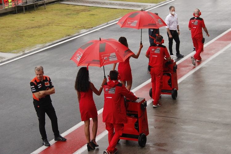 Momen ketika umbrella girl memayungi kru tim Ducati yang hendak ke area start menjelang balapan MotoGP Mandalika, Minggu (20/3/2022) sore. Foto: kompas.com.